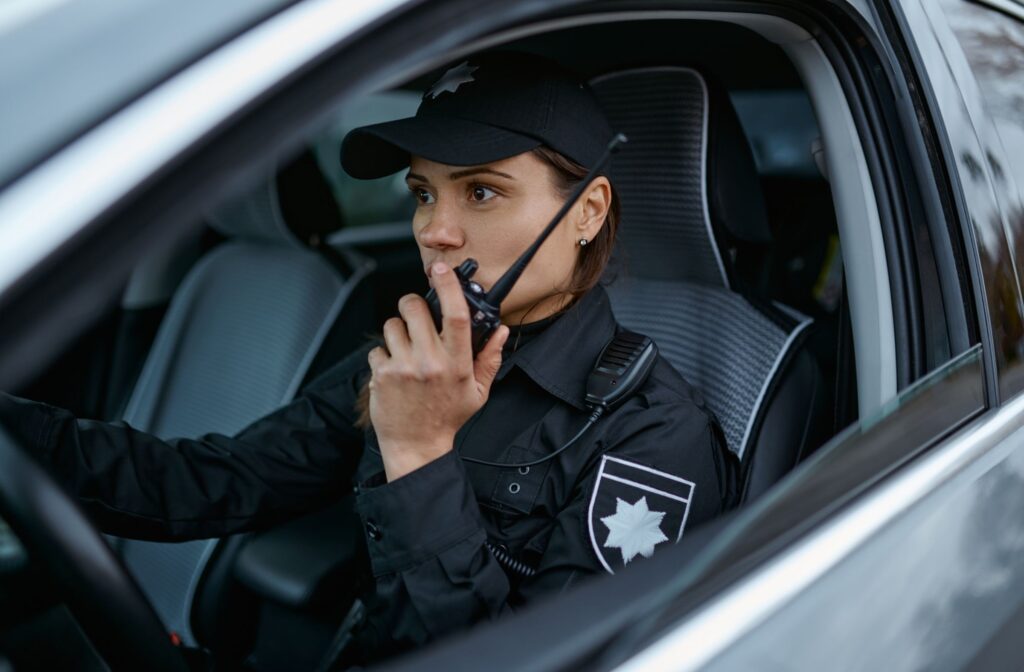 Female police officer using radio in car