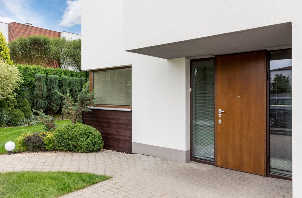 Modern home entrance with lush garden and wooden door
