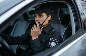 Female police officer using radio in patrol car